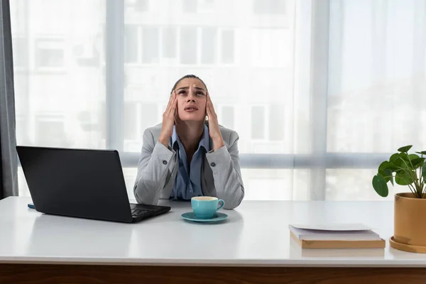 Young woman shouting trying to not to hear the loud noise from neighbor apartment in building while they renovate home and she cant work on laptop or study for college exam because of the noise