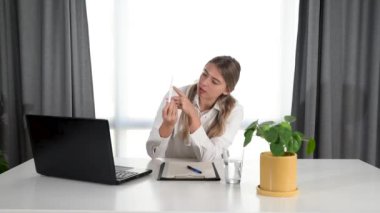 Genç bayan doktor online sunum ve doktor muayenehanesinden hamilelik testi hakkında konuşma. Tıp uzmanı kameraya hamileliğin önlenmesi ve cinsel eğitim hakkında konuşuyor..