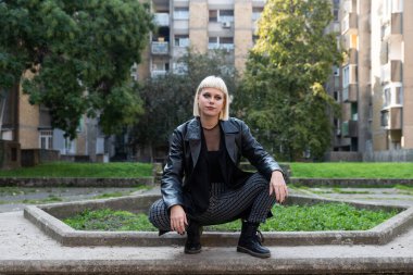 Genç, güzel, güçlü, bağımsız, asi, sarışın bir kadın. Punk müzik ve tarz hayranı pozu. Kendine güvenen Punk-Rock gençlik kültürü sokak tarzı kavramı.