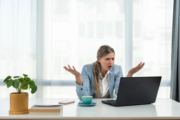 Young frustrated business woman office worker trying to concentrate for her work while she sitting in the company office with old laptop computer and slow internet connection.