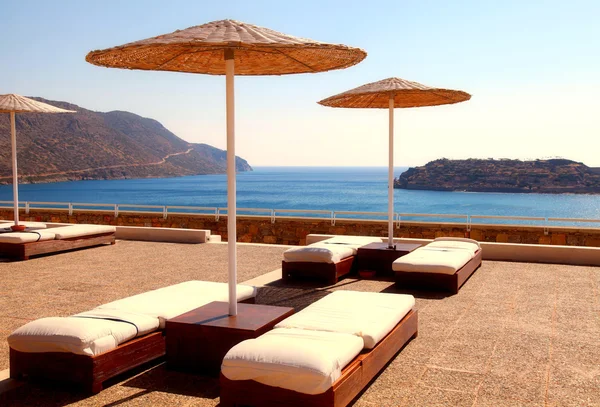 Tumbonas en la terraza en un complejo de verano de lujo (Creta, Grecia ). — Foto de Stock