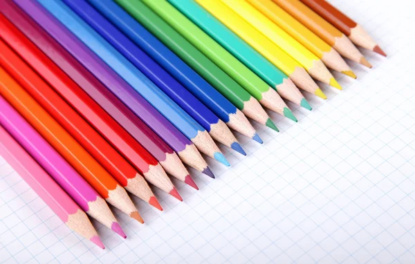 Színes ceruzák, fehér négyzet papír háttér. — Stock Fotó