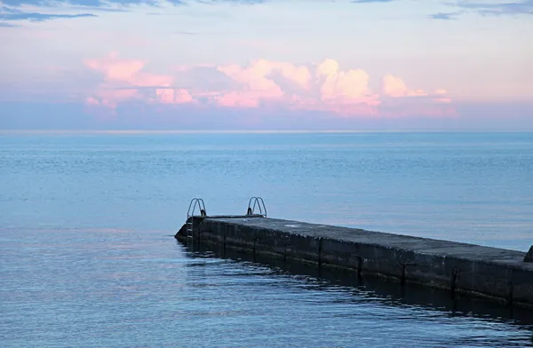 Pier, blauwe hemel en zee op zonsondergang — Stockfoto