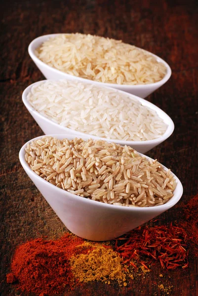 Three bowls with different types of rice and indian spices — Stock Photo, Image