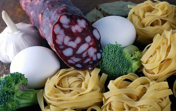 Tagliatelle pasta ingredients on wooden board — Stock Photo, Image
