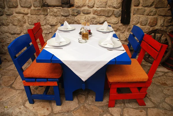 Restaurant extérieur italien avec table et chaises rouges et bleues — Photo