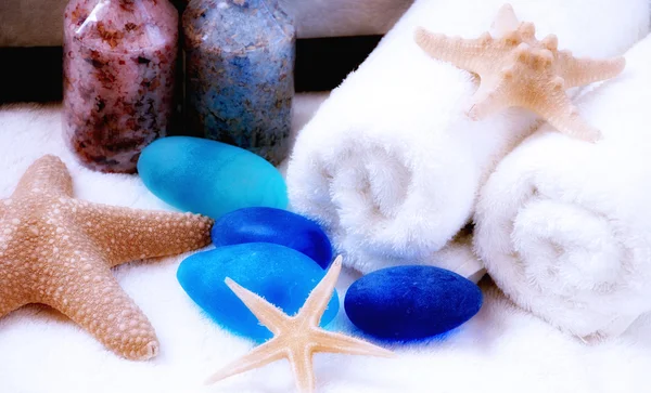 Handdoeken, zeesterren en blauwe stenen — Stockfoto