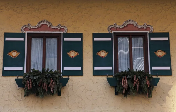 Украшенные типичные баварские окна с зелеными ставнями — стоковое фото