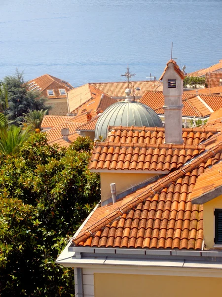 Czerwony dachówka dachy, błękitne morze, zielone rośliny (Czarnogóra) — Zdjęcie stockowe