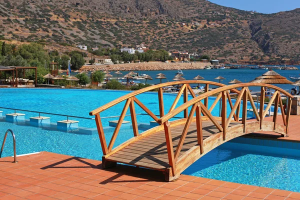 Piscina, pé ponte e praia em resort (Grécia ) — Fotografia de Stock