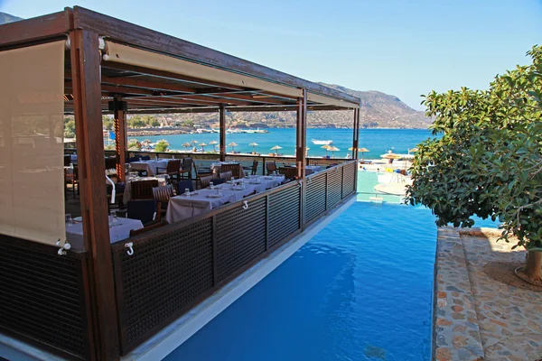 户外咖啡馆、 度假村游泳池和地中海 （克里特岛，希腊) 图库图片