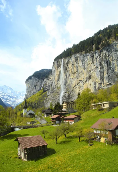 Mountain village with church and waterfall, Alps, Switzerland . — Stock Photo, Image