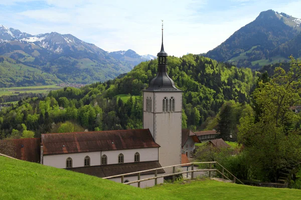 Církev a Alpy pohoří, gruyeres, Švýcarsko — Stock fotografie