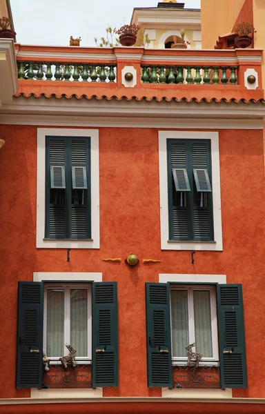 Red stucco house with old green shutter windows in Monaco — Stock Photo, Image