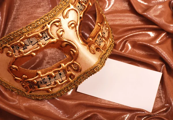 Benátská maska s prázdná Poznámka na zlaté hedvábné pozadí — Stock fotografie