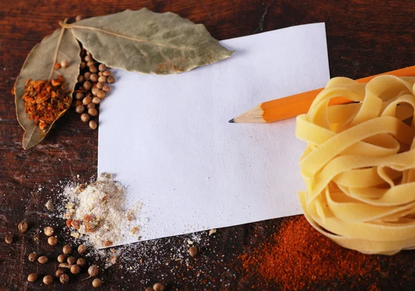 Opmerking, specerijen en pasta op een houten snijplank — Stockfoto