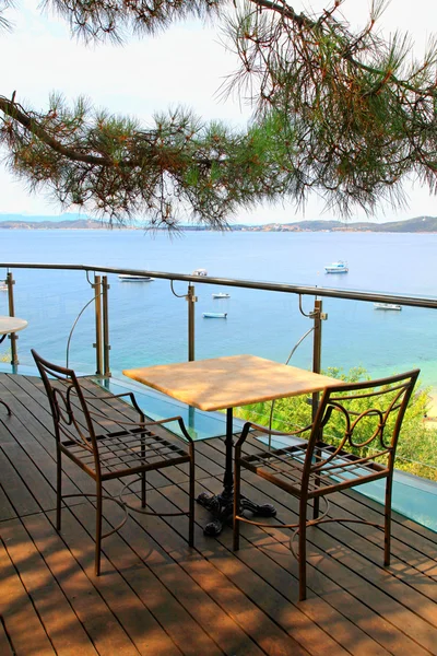 Tabel en ijzer stoelen op terras met uitzicht op zee (Griekenland) — Stockfoto