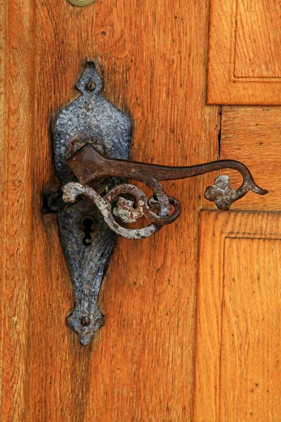 Old rusty iron handle in medieval door — Stock Photo, Image