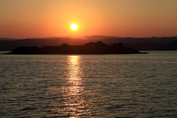 Pôr do sol sobre uma ilha grega no mar Mediterrâneo — Fotografia de Stock