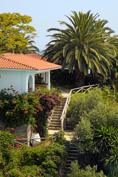 Piękny biały dom w ogrodzie śródziemnomorskim (Grecja). — Zdjęcie stockowe