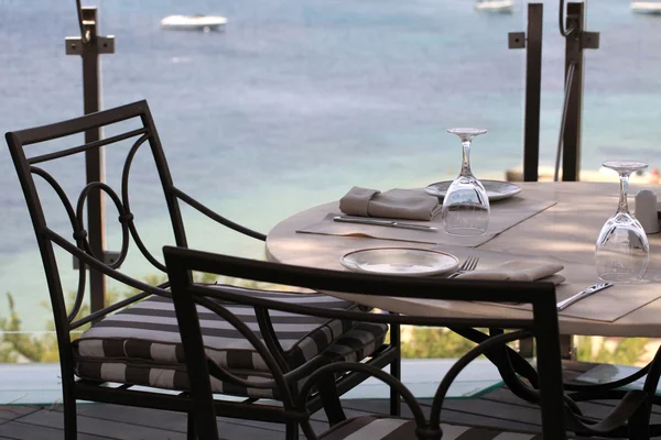 Toalha de mesa, cadeiras de ferro e vista para o mar, Grécia . — Fotografia de Stock