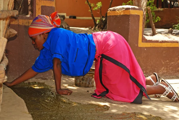 Mujer africana cubierta piso de casa en estiércol — Foto de Stock