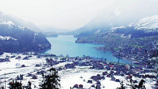 Lago alpino e villaggio in inverno (Svizzera ) — Foto Stock