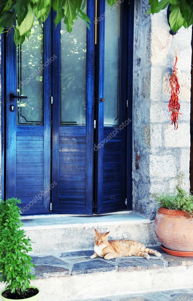 Greek street red cat in blue doorway  (Crete, Greece)