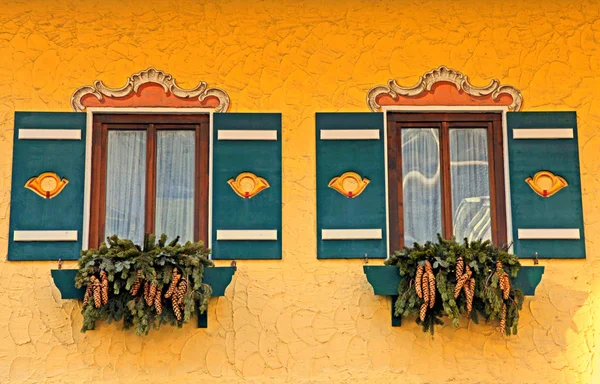 Украшенные типичные баварские окна с зелеными ставнями — стоковое фото