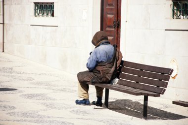 evsiz bir adam bir banka Lizbon, Portekiz. 