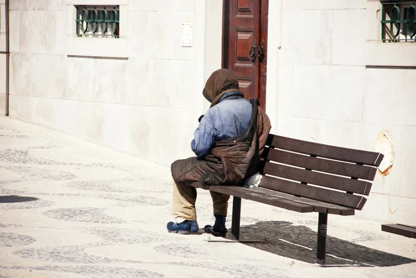 En hemlös man på en bänk i Lissabon, portugal. — Stockfoto