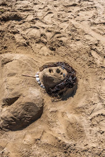 Kumsalda kumdan adam heykeli süslenmiş.