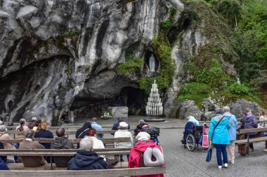 Lourdes, Fransa - 9 Ekim 2021: Katolik Pilgirmler Lourdes Tespih Bazilikası 'ndaki Massabielle Grotto' da bir ayine katıldılar.