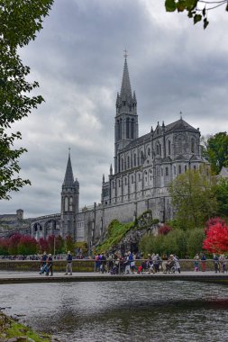 Lourdes, Fransa - 9 Ekim 2021: Lourdes 'teki Gave de Pau nehrinden Tespih Bazilikası Kilisesi manzarası