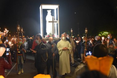 Lourdes, Fransa - 9 Ekim 2021: Bakire Meryem Anıtı, Lourdes 'teki Marian Torchlight Geçit Töreni sırasında kalabalıklar arasında taşınır.