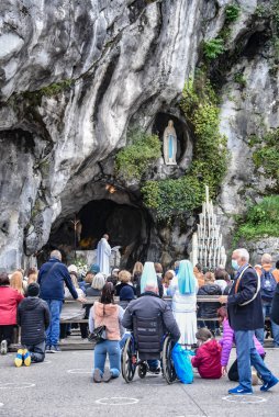Lourdes, Fransa - 9 Ekim 2021: Katolik Pilgirmler Lourdes Tespih Bazilikası 'ndaki Massabielle Grotto' da bir ayine katıldılar.