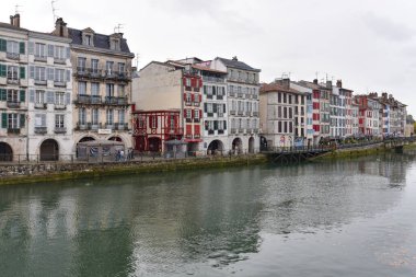 BAYONNE, FRANCE - 30 Ekim 2021: Bayonne, Aquitaine, Fransa merkezindeki La Nive nehri kıyısındaki eski evler