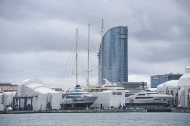 Barselona, İspanya - 24 Kasım 2021: Arka planda W oteli bulunan Barcelona tersanesinde yelken açan yatlar ve tekneler