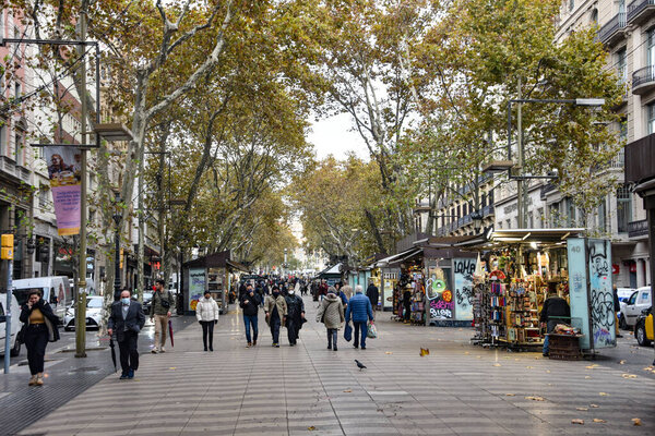 Barcelona, Spain - 23 Nov, 2021: Crowds strolling along the famous La Rambla avenue on an Autumn day, Barcelona, Spain