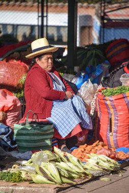 Urubamba, Peru - 30 Haziran 2022: Urubamba merkez pazarında sebze ve ürün satan kadın. Kutsal Vadi, Cusco, Peru