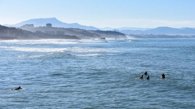 Biarritz, France - 15 Jan, 2022: Surfers on the Cote des Basques beach clipart