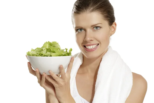 Молодая женщина ест салат после фитнеса — стоковое фото