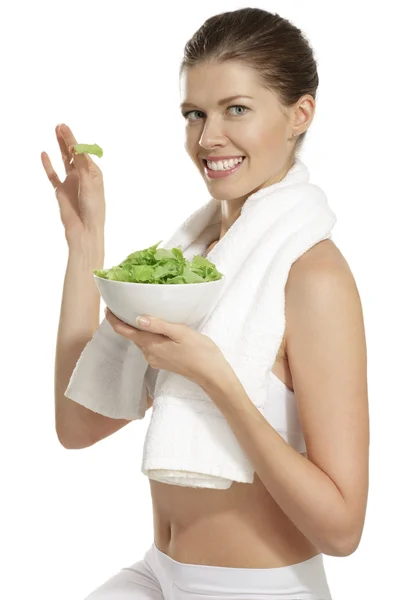 Mladá žena jíst salát po fitness — Stock fotografie