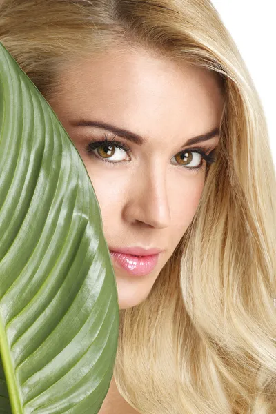 Schönheit blonde Frau mit einem grünen Blatt auf weiß — Stockfoto