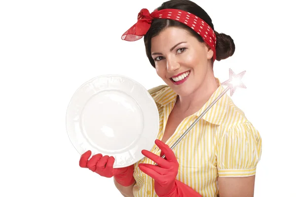 Young beautiful woman housewife showing a magic wand on dishes — Stock Photo, Image