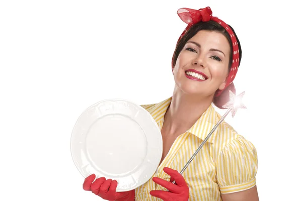 Young beautiful woman housewife showing a magic wand on dishes — Stock Photo, Image