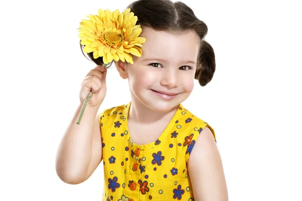 Mooie babymeisje met een gele bloem in haar hand — Stockfoto