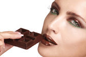 Nahaufnahme eines schönen Modells, das dunkle Schokolade probiert