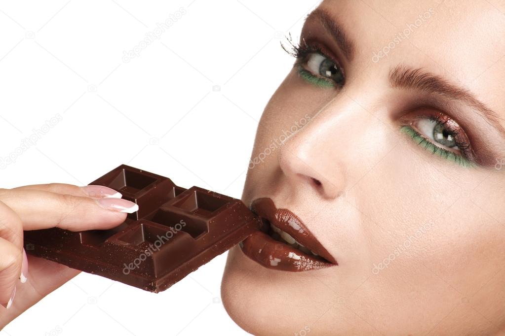 close up of a beautiful model tasting dark chocolate