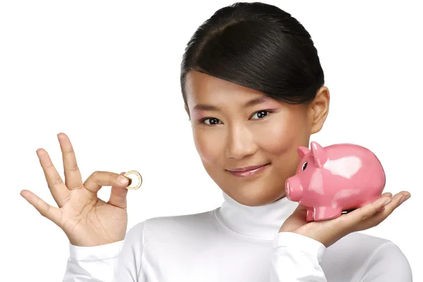 Beautiful happy chinese girl showing a piggybank — Stock Photo, Image